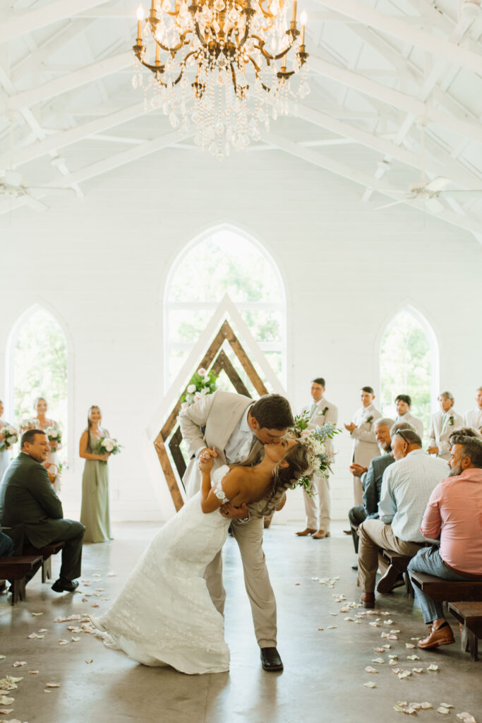 Bride and groom kiss down the isle in chapel in tennessee wedding